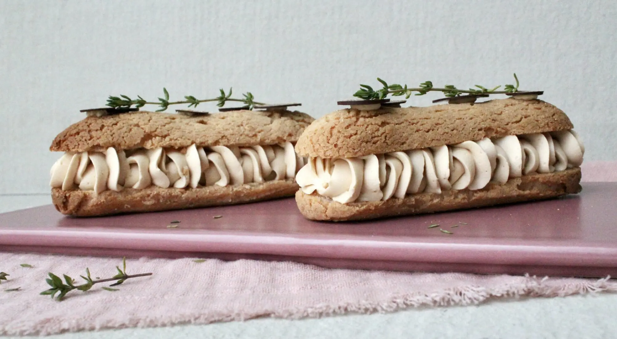 Portionsanrettede vandbakkelses eclair med saltkaramel, romcreme og krakkeleret dej og chokolade