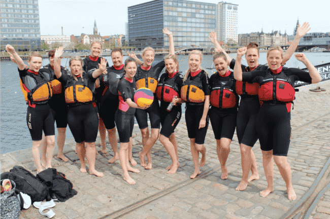Ditte Julie og hendes veninder står op kajen ved Islands Brygge i våddragt og redningsvest - klar til at spille kajak polo.