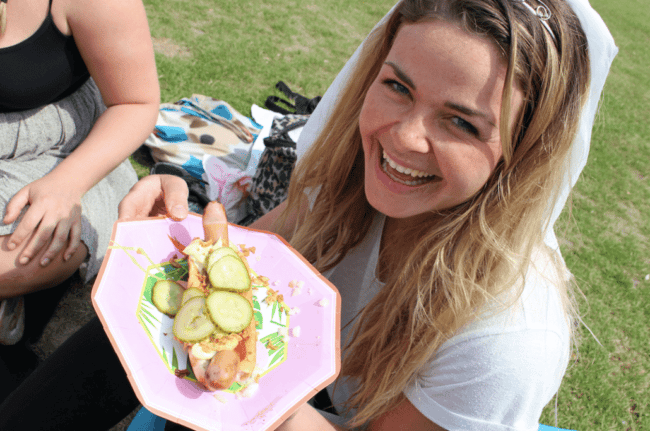 Ditte Julie spiser en hotdog af en lyserød paptallerken.
