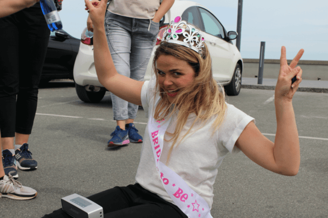 Ditte Julie sidder på asfalten med en højtaler på benene og prinsessekrone på.