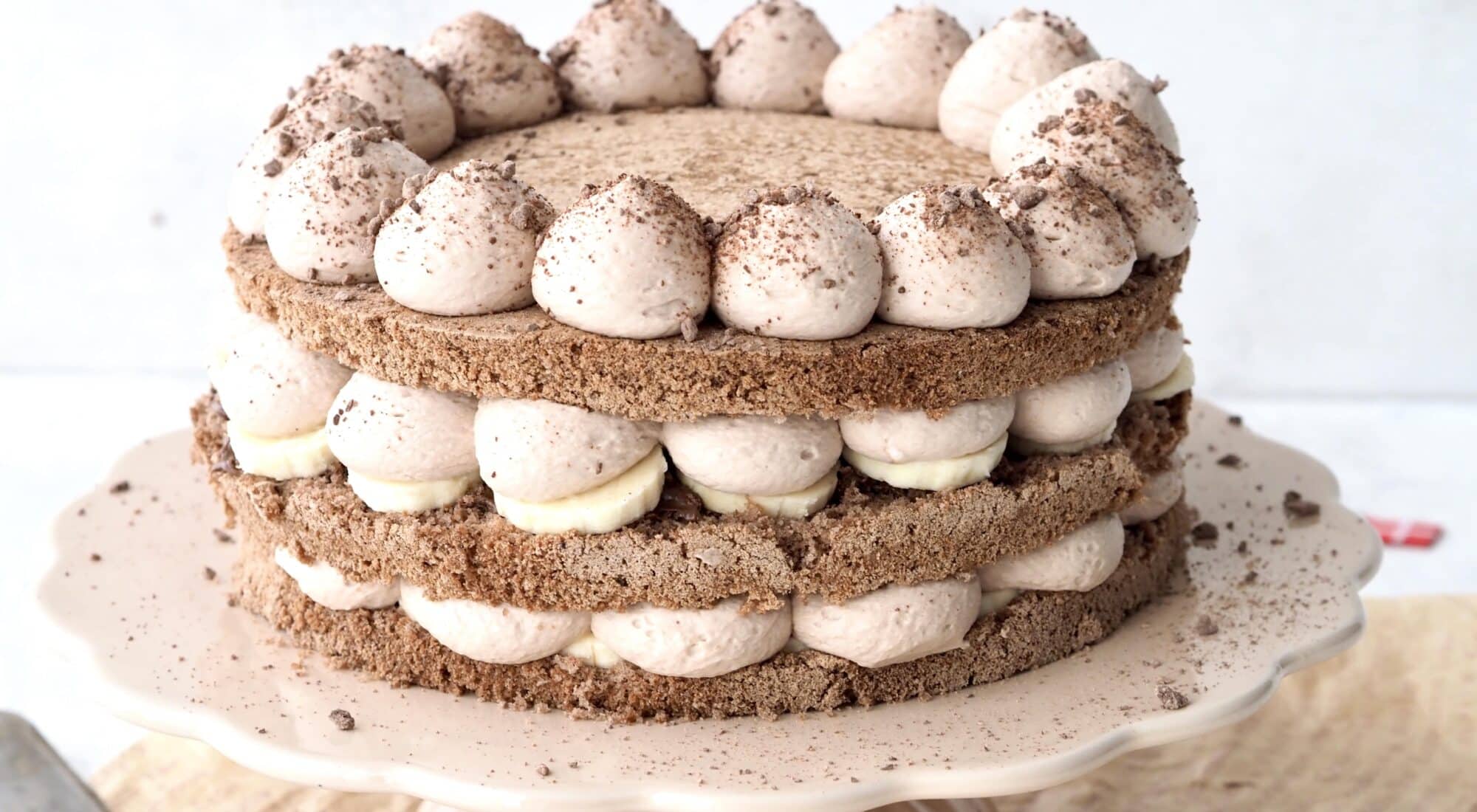 Bananlagkage af glutenfri kakaobunde og creme af nutella. Lagkagen er drysset med finthakket chokolade